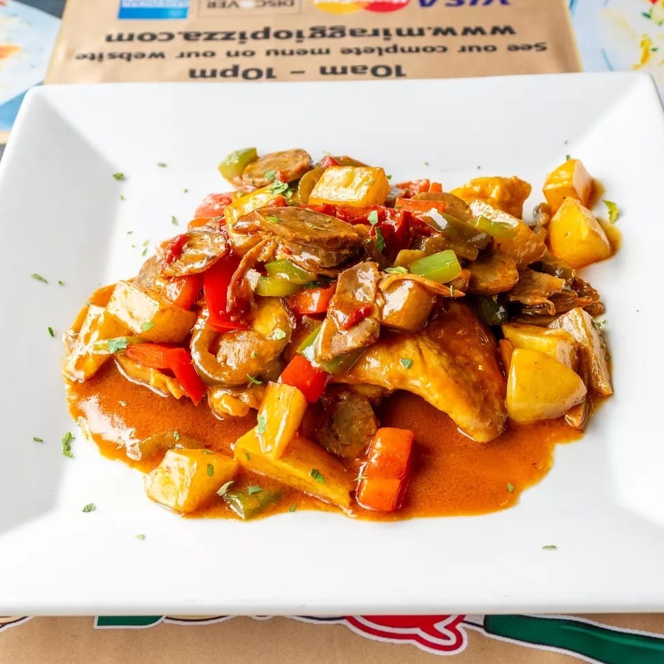 Chicken wings with potatoes, red and green peppers, and mushrooms in a rich sauce.