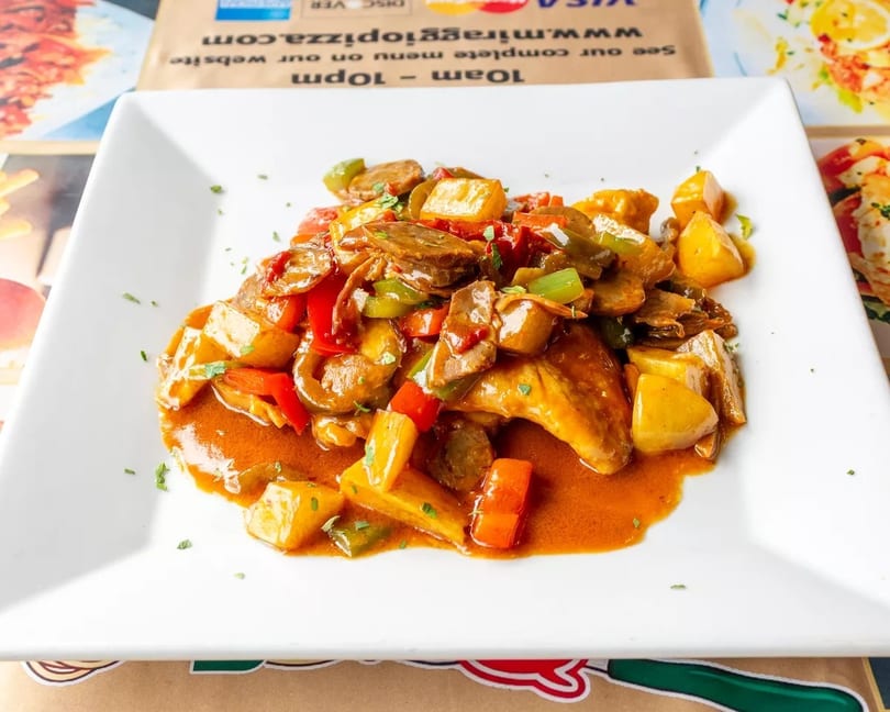 Chicken wings with potatoes, red and green peppers, and mushrooms in a rich sauce.
