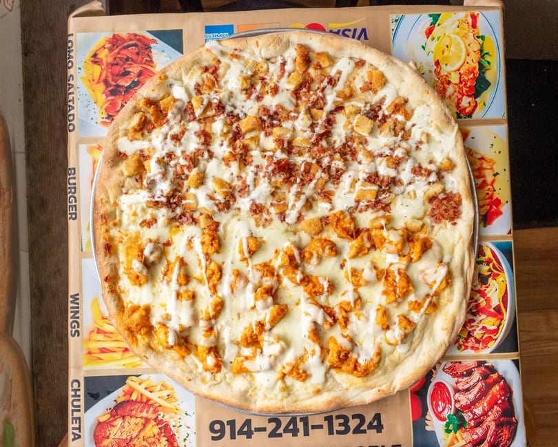 Half buffalo chicken, half bacon chicken pizza with white sauce on a menu background.